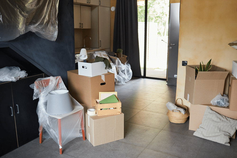 Interieur d'une maison rempli de cartons et en désordre illustrant le besoin de connaître le tarif pour débarrasser une maison